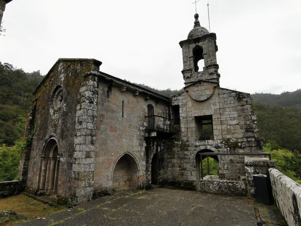 Vista del Monasterio de Caaveiro entre árboles, en el corazón del Eume
